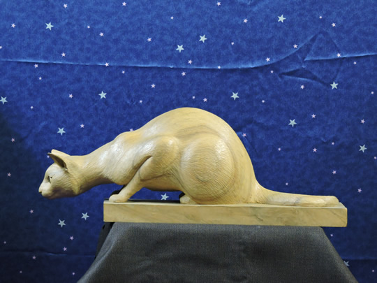 獲物を見る時の木彫りの猫　wood carved cat of when watching prey