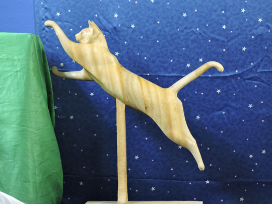 棚に飛び上がる時の木彫りの猫  wood carving cat of when jump up shelf